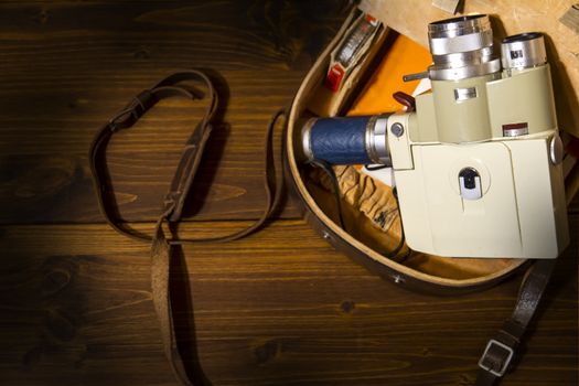 Vintage Super 8 cine camera from the 1960 with his original case on wooden background