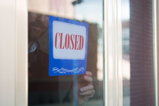 Business man hanging closed sign for quarantine