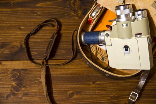 Vintage Super 8 cine camera from the 1960 with his original case on wooden background