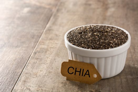 Chia seeds in bowl on wooden table