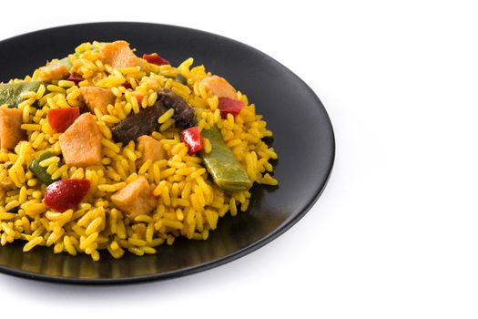 Fried rice with chicken and vegetables on black plate isolated on white background