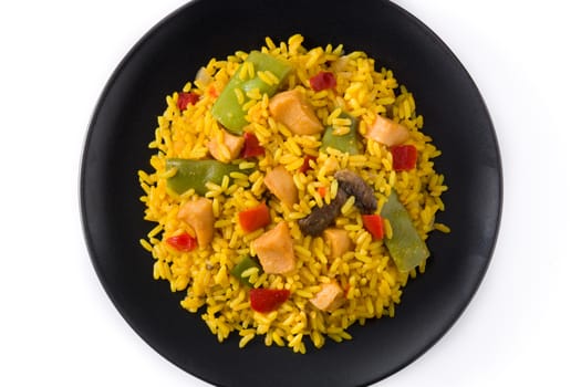 Fried rice with chicken and vegetables on black plate isolated on white background