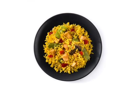 Fried rice with chicken and vegetables on black plate isolated on white background