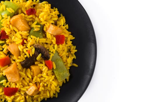 Fried rice with chicken and vegetables on black plate isolated on white background