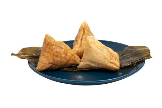Three opened ZhongZi - traditional Chinese rice dish in bamboo leaves on a blue plate isolated on white