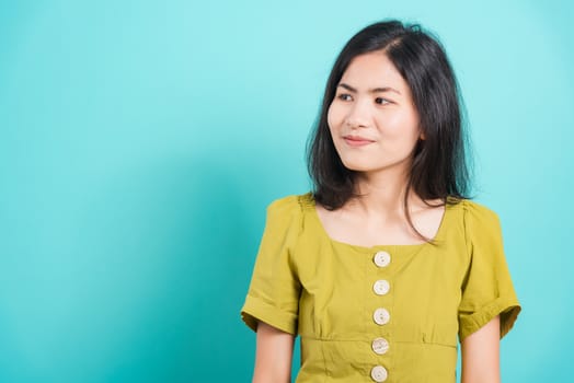 Portrait Asian beautiful young woman standing smile seeing white teeth, She looking at the side, shoot photo in studio on white background. There was a copy space to put text on the right-hand side.