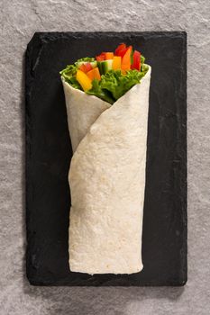 Vegetable tortilla wraps on gray stone background