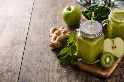 Healthy green smoothie in jar on wooden table