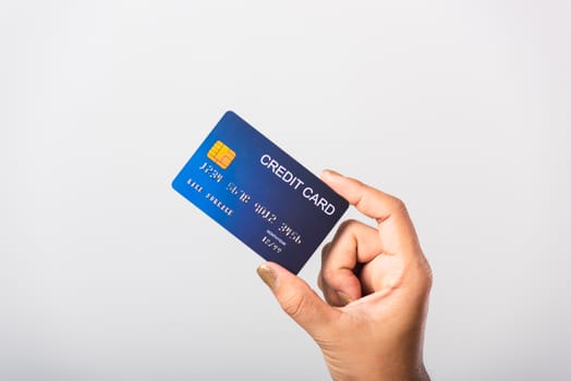 Close up hand of Asian woman she holding bank credit card for pay money online shopping, studio shot isolated on white background