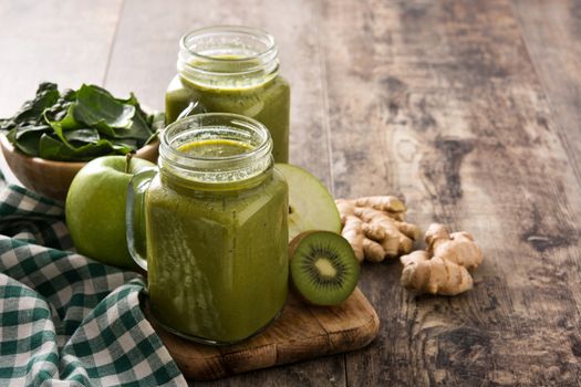 Healthy green smoothie in jar on wooden table