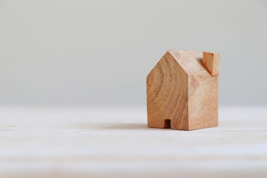 Wooden house model with copy space on the left.