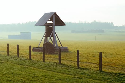 barbed wire fence and Peace bell in German concentration and extermination camp Majdanek. Lublin, Poland