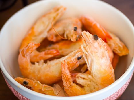 Bowl filled with fresh shrimps in man hands. Food for diet - Grilled shrimps with mango salad. Home cook in Asian kitchen.
