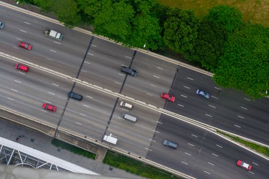 Aerial shot of highway, view from above, with easy traffic, cars and trees on the side