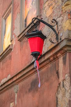 old street lamp with a red canvas on the ancient wall of a house in Lublin, Poland