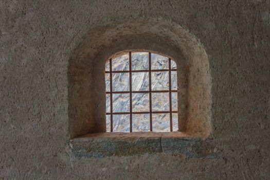 detail of a window with wrought iron grating of an ancient castle