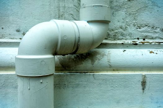 Close-up Drain Pipe on White Concrete Wall Background.