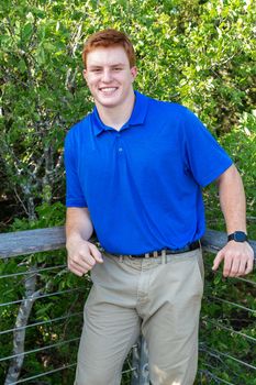 Handsome, red- headed young man posing for his High School graduation photos. Very attractive and athletic looking young boy.