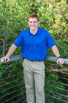 Handsome, red- headed young man posing for his High School graduation photos. Very attractive and athletic looking young boy.