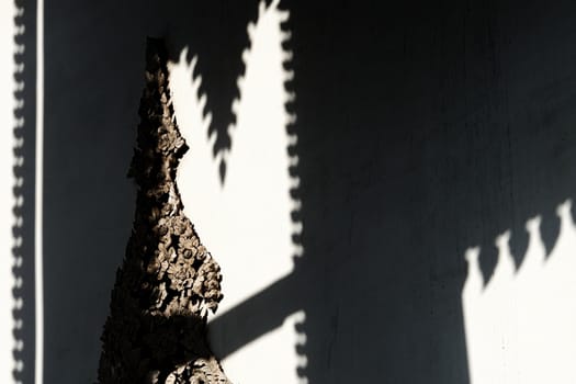 Vintage Thai Sculpture on Concrete Wall with Shadow Background.