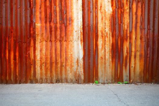 Old Rusty Zinc Wall Background with Concrete Pavement.