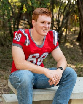 Handsome, red- headed young man posing for his High School graduation photos. Very attractive and athletic looking young boy.