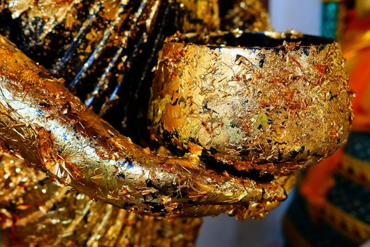 Close-up Golden Alms Bowl on Buddha Image Hand.