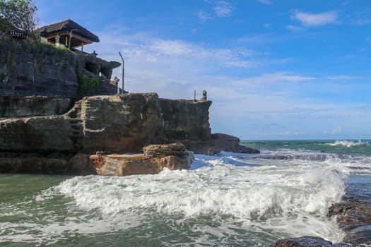 Beautiful Tanah Lot Temple in Bali Indonesia epic scene - nature and architecture background. Pilgrimage Temple of Pura Tanah Lot is perched dramatically on a large coastal rock.
