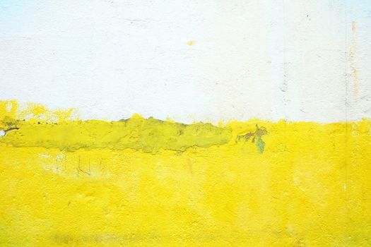 Yellow and White in Half Painting on Old Concrete Wall Background.