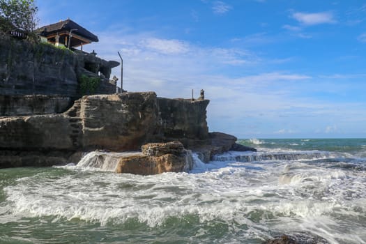 Beautiful Tanah Lot Temple in Bali Indonesia epic scene - nature and architecture background. Pilgrimage Temple of Pura Tanah Lot is perched dramatically on a large coastal rock.