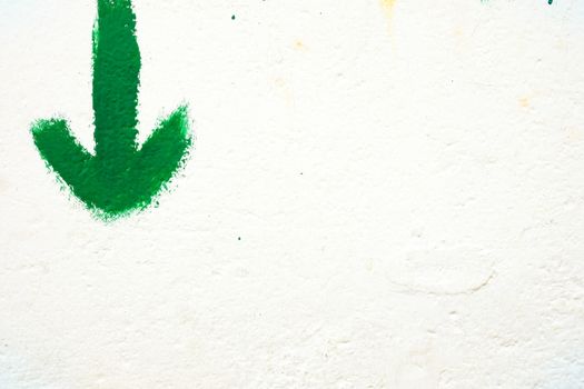 Green Arrow on White Concrete Wall Background.