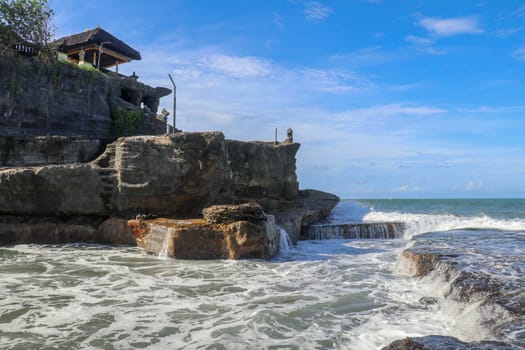 Beautiful Tanah Lot Temple in Bali Indonesia epic scene - nature and architecture background. Pilgrimage Temple of Pura Tanah Lot is perched dramatically on a large coastal rock.