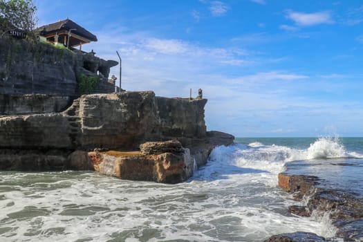 Beautiful Tanah Lot Temple in Bali Indonesia epic scene - nature and architecture background. Pilgrimage Temple of Pura Tanah Lot is perched dramatically on a large coastal rock.
