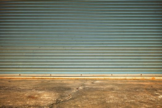 Old Folding Metal Door with Concrete Pavement.