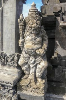 Closeup of stone statue in Temple Batu Bolong near to Tanah Lot in Bali, Indonesia. A carved statue with fine details that stands outside the entrance to Hindu temple as a guardian. Balinese culture.