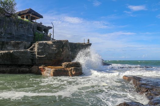 Beautiful Tanah Lot Temple in Bali Indonesia epic scene - nature and architecture background. Pilgrimage Temple of Pura Tanah Lot is perched dramatically on a large coastal rock.
