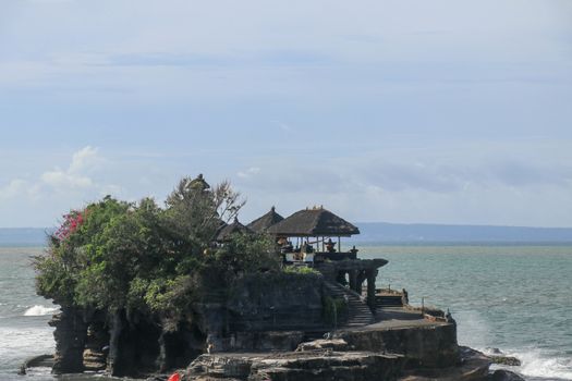 Beautiful Tanah Lot Temple in Bali Indonesia epic scene - nature and architecture background. Pilgrimage Temple of Pura Tanah Lot is perched dramatically on a large coastal rock.