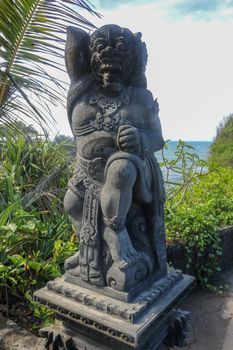 Closeup of stone statue in Temple Batu Bolong near to Tanah Lot in Bali, Indonesia. A carved statue with fine details that stands outside the entrance to Hindu temple as a guardian. Balinese culture.