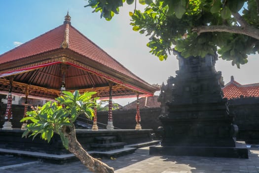 Temple on the Indian Ocean coast near the Sacred Balinese temple Tanah Lot. Pura Batu Bolong on the edge of a cliff at coastline with hole in the rock. Holy place for local indonesian people