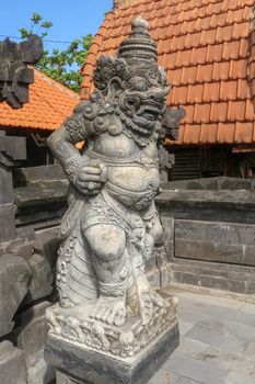 Closeup of stone statue in Temple Batu Bolong near to Tanah Lot in Bali, Indonesia. A carved statue with fine details that stands outside the entrance to Hindu temple as a guardian. Balinese culture.