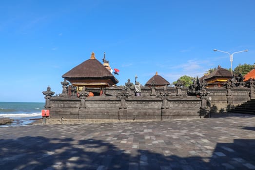 Temple on the Indian Ocean coast near the Sacred Balinese temple Tanah Lot. Pura Batu Bolong on the edge of a cliff at coastline with hole in the rock. Holy place for local indonesian people
