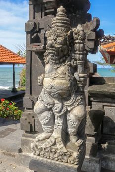 Closeup of stone statue in Temple Batu Bolong near to Tanah Lot in Bali, Indonesia. A carved statue with fine details that stands outside the entrance to Hindu temple as a guardian. Balinese culture.