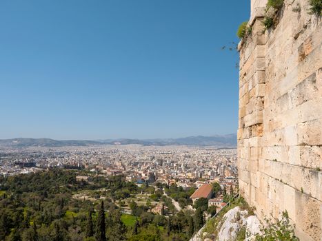 Panoramic view of Athens city and a stone wall of Acropolis hill