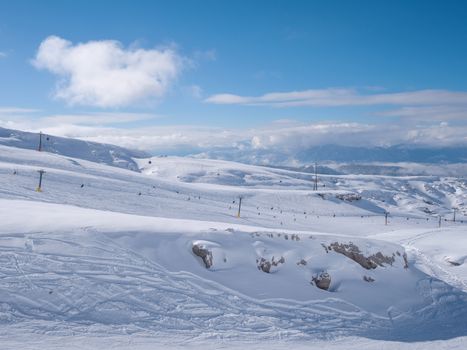 Parnassos mountain with snow and people on the slopes in a sunny day