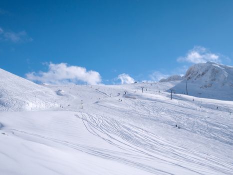 Parnassos mountain with snow and people on the slopes in a sunny day