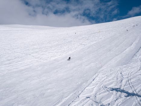 Parnassos mountain with snow and people on the slopes in a sunny day