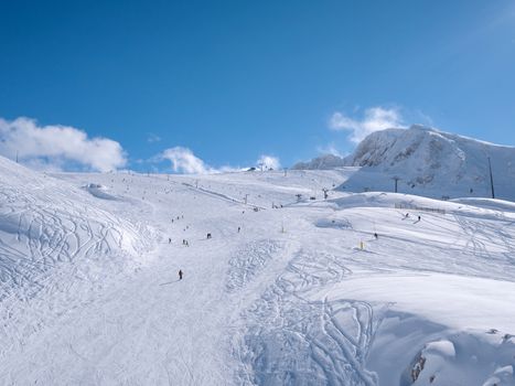 Parnassos mountain with snow and people on the slopes in a sunny day