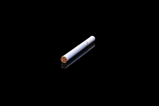 white filter cigarette on isolated black background with reflection