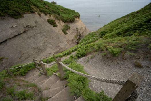 Some wooden steps leading down to a beach from a cliff