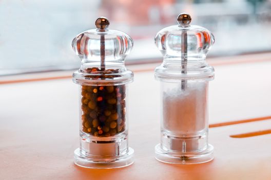 glass salt and pepper shakers stand on a table